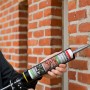 Anwendung von Soudal Express Mörtel Zementgrau zum Füllen einer Fuge in einer Ziegelwand.