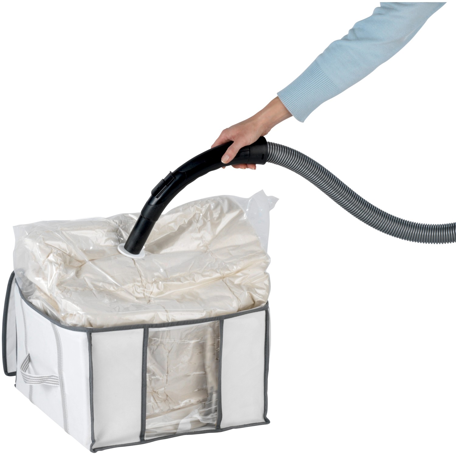 Wenko Vakuum Soft Box S: Weiße Textilbox mit Vakuumsack wird mit Staubsauger entlüftet.