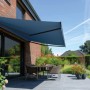 Halbkassettenmarkise Reno, 3x2 m, anthrazitfarbenes Gehäuse, blaues Tuch, montiert an Hauswand über Terrasse.