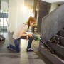 Frau saugt Treppe mit Bosch Akku-Staubsauger EasyVac 12. Inkl. Zubehör-Set.