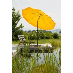 Goldgelber Schneider Balkonschirm Aquila Ø 250 cm mit Knickfunktion auf Terrasse am Wasser.