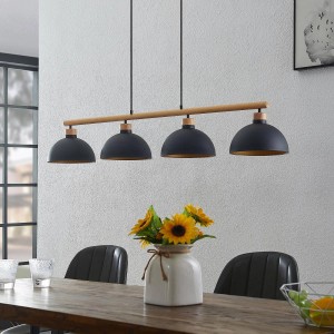 Schwarze Lindby Pendelleuchte Tirzana im Retro-Stil mit 4 Lampenschirmen aus Metall über einem Esstisch.