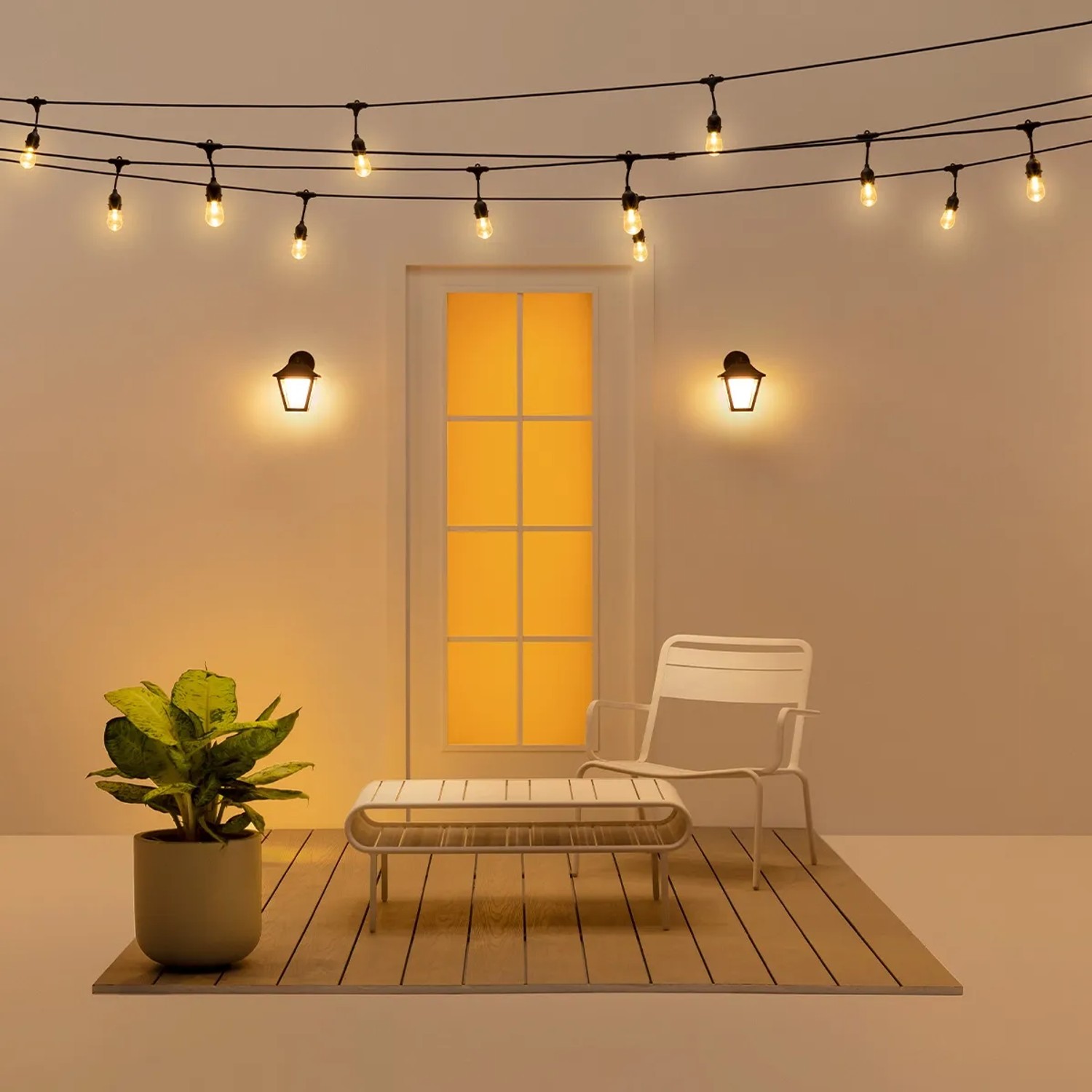 Smarte WiZ Außenwandleuchte Classic in Schwarz, mit Lichterkette und Gartenmöbeln.
