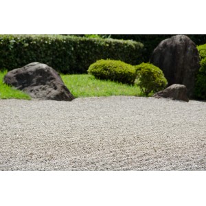 Bunter Quarzkies (6-8 mm) als Zierkies im Garten, mit Steinen und Pflanzen dekoriert.