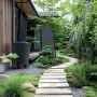 Graue Waterform Regentonne Smooth 510 l im Garten neben einem Haus.