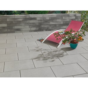 Verlegte Kann Terrassenplatte Casavera Grau, 60x40 cm, mit Liege und Bepflanzung.