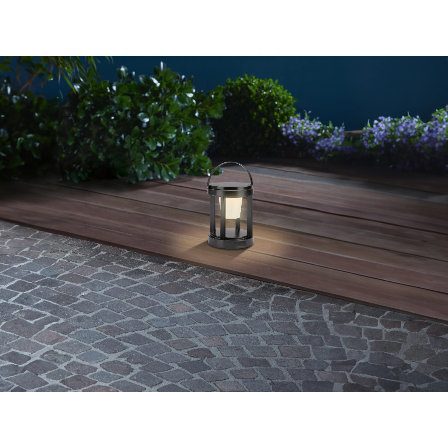 Schwarze Solar-LED-Laterne, rund, Ø 13 cm x 18 cm, mit warmweißem Licht und Tragebügel.
