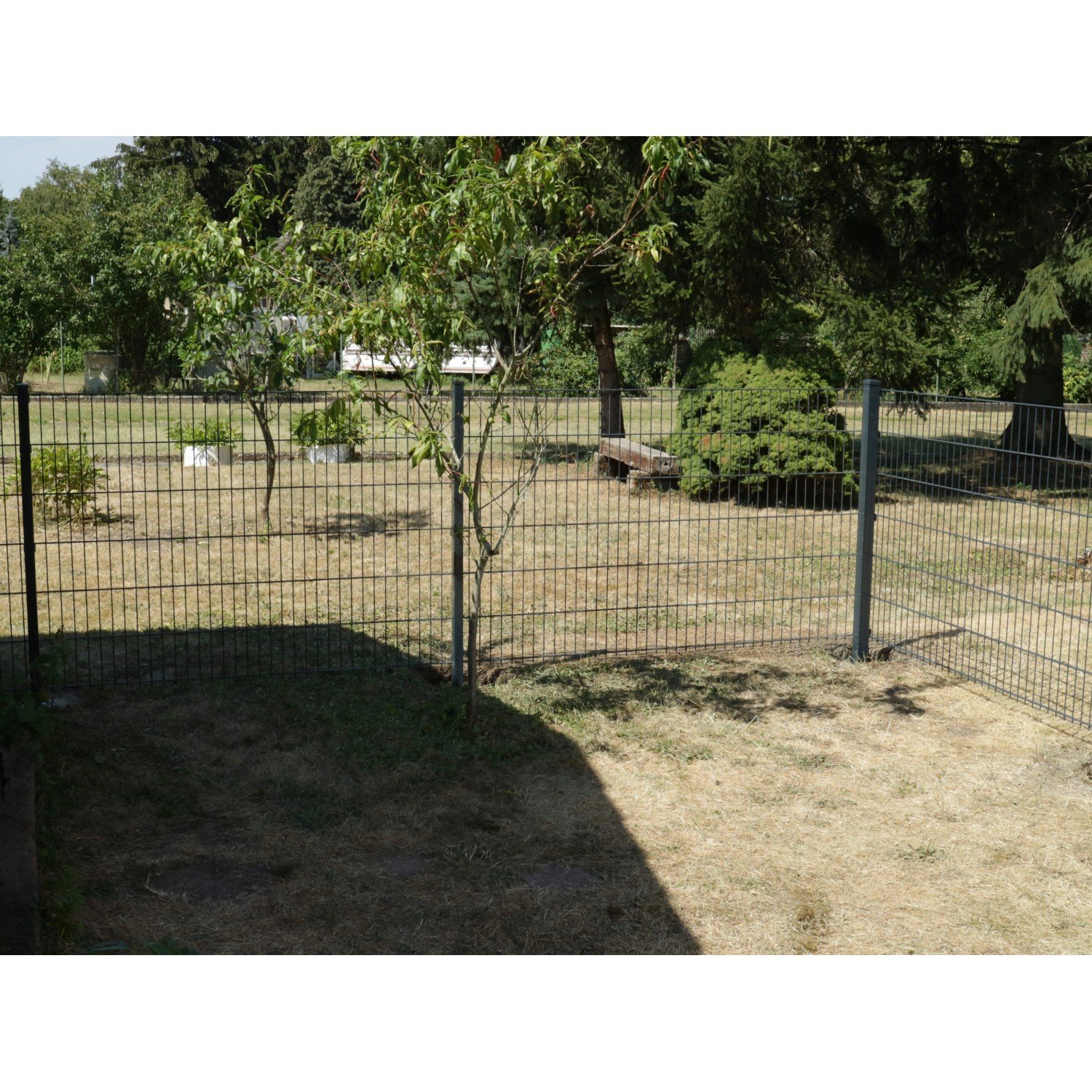 Anthrazitfarbener Doppelstabmattenzaun aus Metall, 183x201 cm, umzäunt einen Garten.