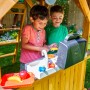 Zwei Kinder spielen in der Spielküche des Zwerkules Spielturm Bolzo mit Rutsche und Schaukel.