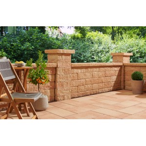 Sandsteinfarbene Bruchsteinmauer mit Pfeilerabdeckplatte im Garten.