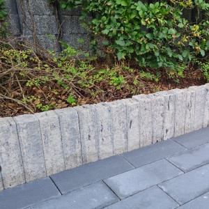 Diephaus Mauerstein Maximo Nola, weiß-schwarz, als Beeteinfassung und Palisade im Garten.
