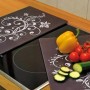 Westfalia Herdabdeckplatten Nero 2er-Set mit Ornament-Design auf Glaskeramikherd mit Gemüse.