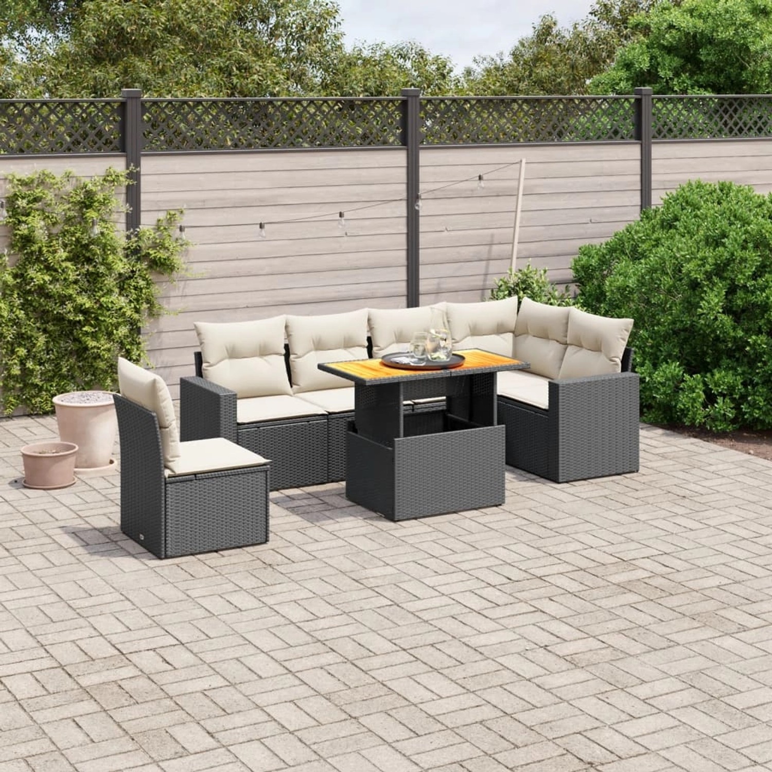 Schwarze 7-tlg. vidaXL Garten-Sofagarnitur aus Poly Rattan mit cremefarbenen Kissen und höhenverstellbarem Tisch.