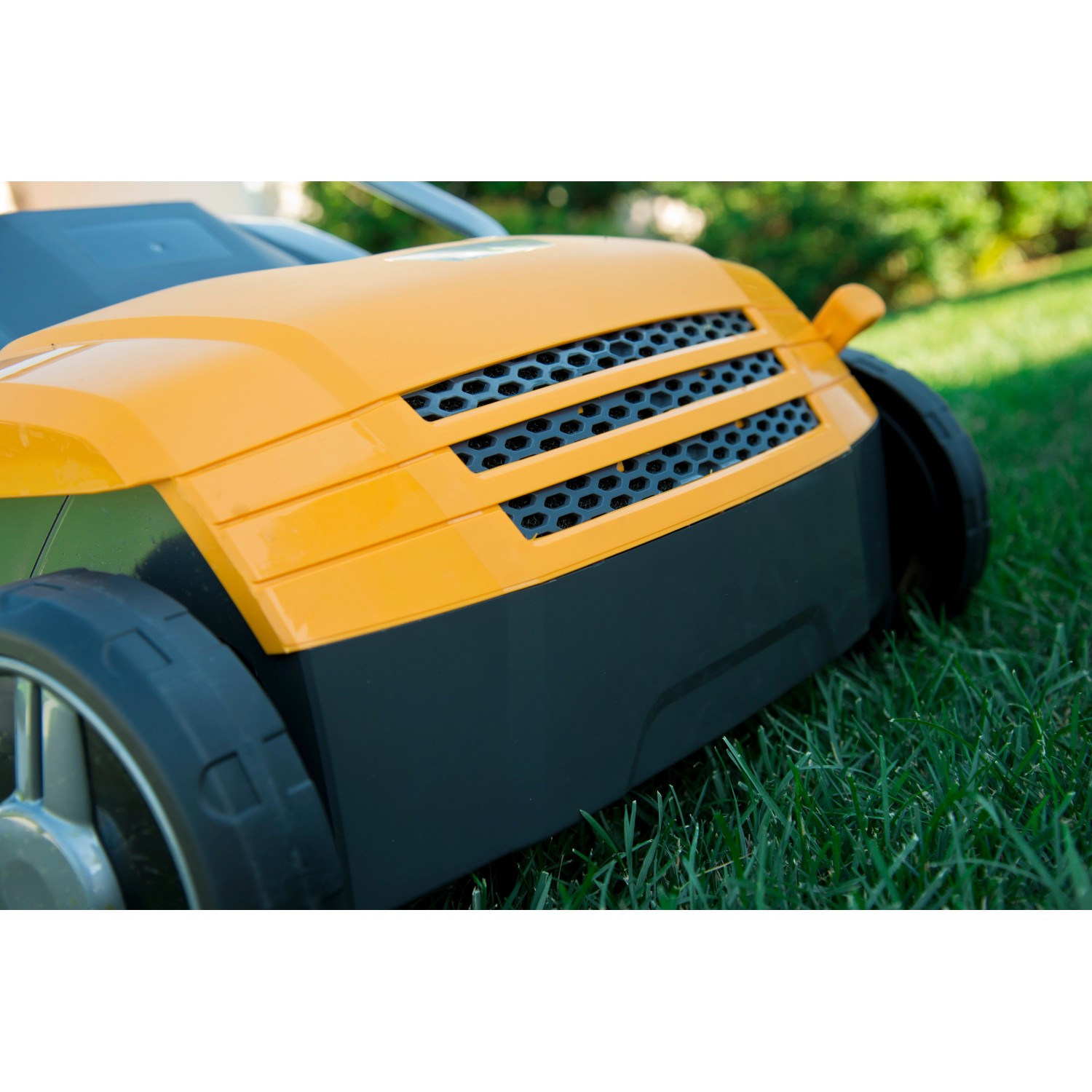 Stiga Elektro-Vertikutierer SV 213 E, gelb-schwarz, auf Rasen. Detailaufnahme.