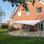 Cremeweißes Toldoro Sonnensegel (4x3m) spendet Schatten auf Terrasse mit Gartenmöbeln.