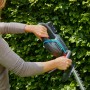 Gardena Akku-Heckenschere ComfortCut 50/18V im Einsatz vor grüner Hecke. Kabellose Gartenarbeit.