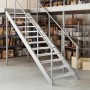 Silberne Gitterroststufe aus verzinktem Stahl, rutschfest. Ideal für Industrietreppen in Lagerhallen.