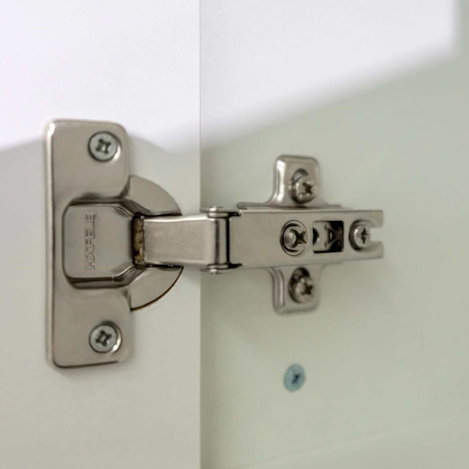 Detailaufnahme: Scharnier an weißer Flex-Well Küchenzeile Florida Tür.