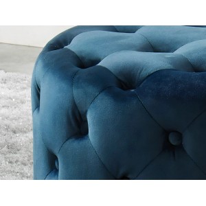 Marineblauer Samt-Sitzhocker Fourca, gesteppt mit Knöpfen, auf hellem Teppich. Eleganter Polsterhocker.