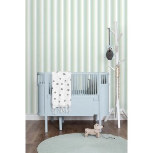 ESTAhome Vliestapete mit mintgrünen Regenbogenstreifen im Kinderzimmer, neben blauem Babybett und Spielzeug.