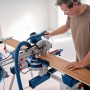 Bosch Professional GCM 305-216 D Kapp- und Gehrungssäge beim Zuschnitt eines Holzbretts.