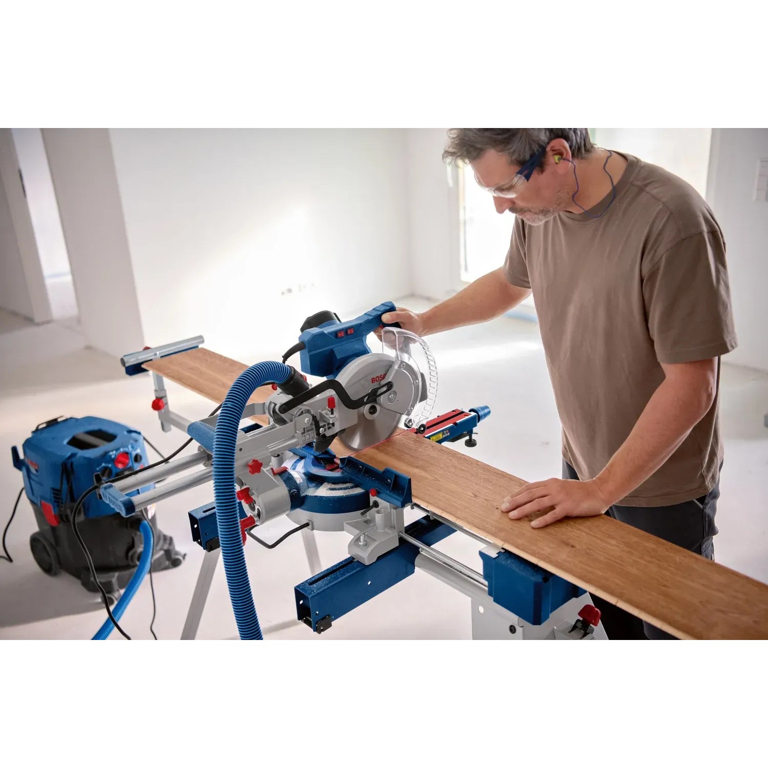 Bosch Professional GCM 305-216 D Kapp- und Gehrungssäge beim Zuschnitt eines Holzbretts.