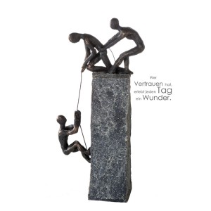 Gilde Skulptur Assistance: Bronzefarbene Kunstharz-Figuren helfen sich am grauen Sockel. Dekorative Figur 43 cm.
