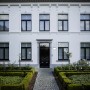 Moderne Lutec Solar-Wandleuchte Bubble aus Edelstahl an weißer Hauswand.