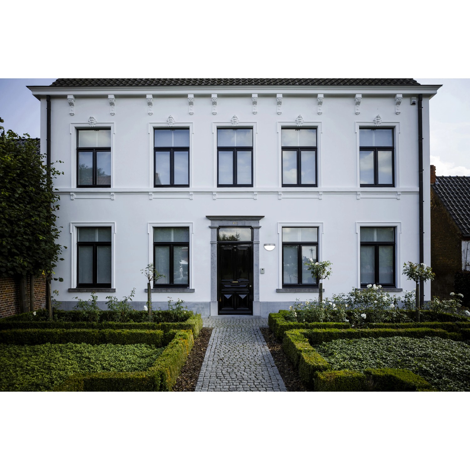 Moderne Lutec Solar-Wandleuchte Bubble aus Edelstahl an weißer Hauswand.