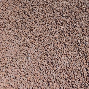 Nahaufnahme von rotbraunem Galamio Lavamulch (8-16 mm) als Beetabdeckung.