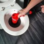 Rothenberger Industrial Pressluft-Rohrreiniger im Einsatz in einer Toilette.