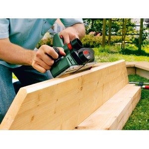 Bosch PHO 3100 Hobel in Aktion auf einem Holzbrett. Elektrohobel für präzise Holzbearbeitung.