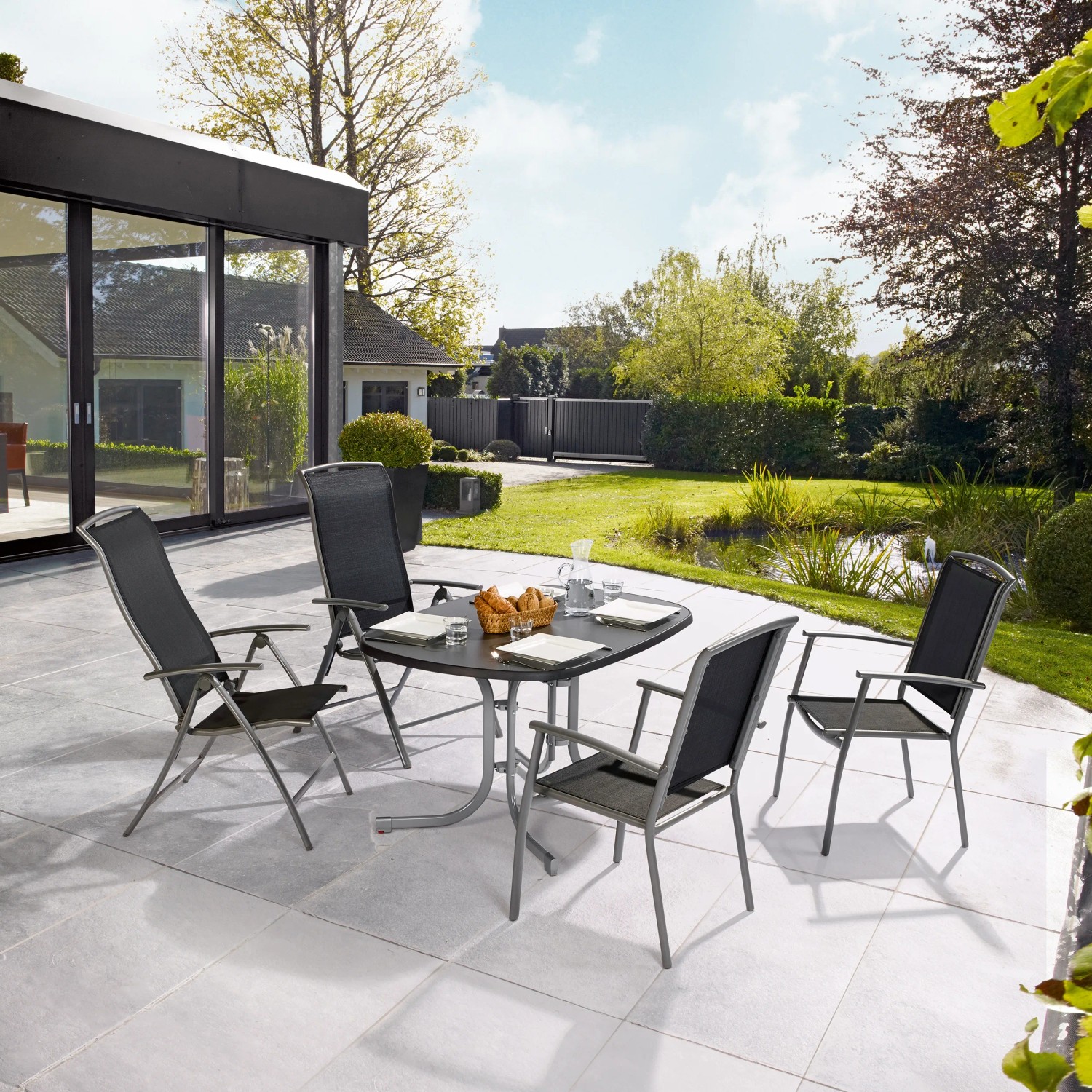 Gartenmöbel-Set: Klappsessel Vigo mit Tisch auf Terrasse. Schwarze Textilen-Bespannung, verstellbare Rückenlehne.