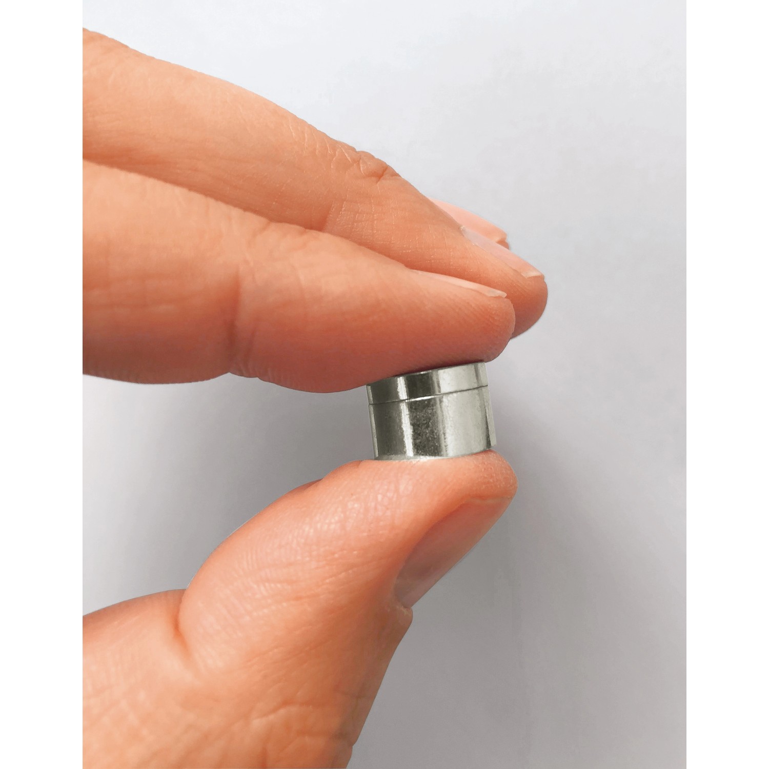 Fix-o-moll Magnetschnäpper Neodym, silberfarben, in Hand gehalten.