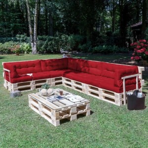 Rotes Beautissu Paletten-Rückenkissen 120x40x10cm auf einer L-förmigen Palettenlounge im Garten. Dickes, gestepptes Outdoor-Kissen.