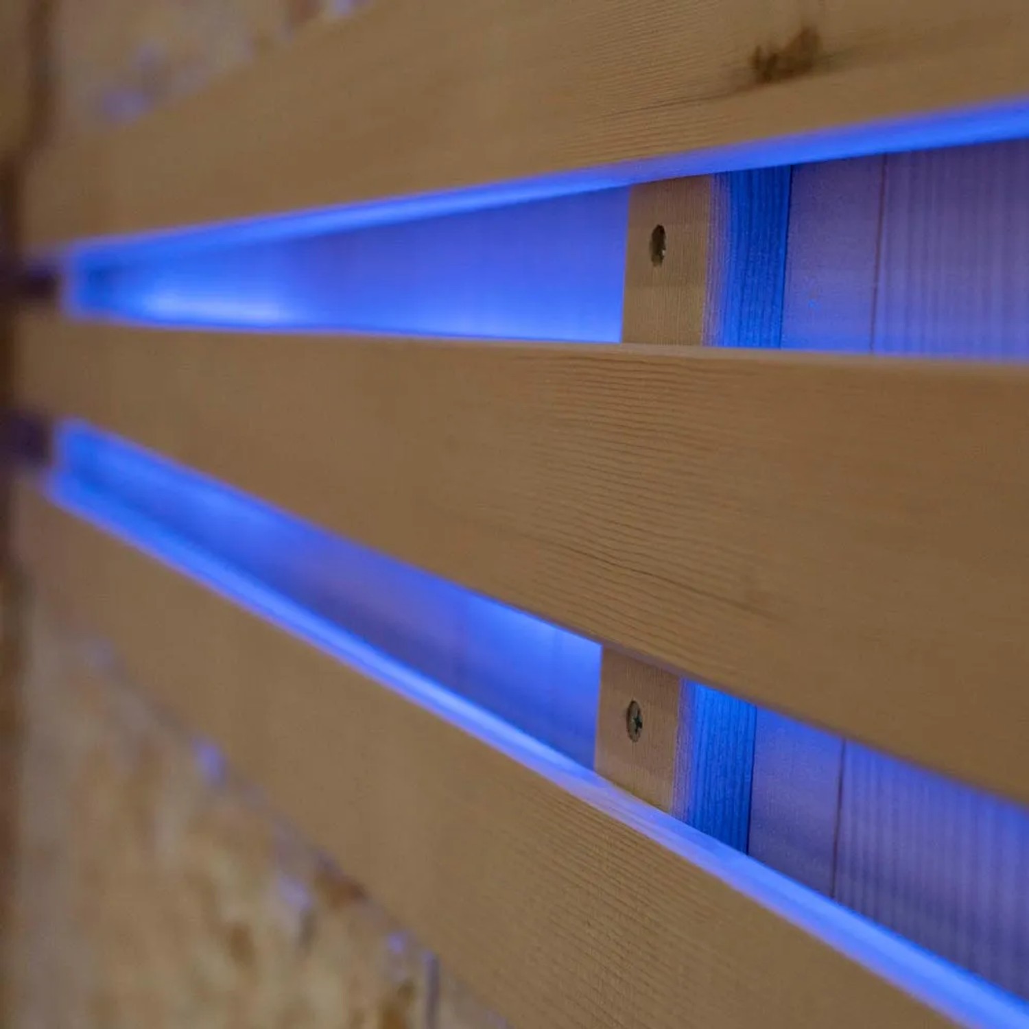 Detailaufnahme der Tannenholz-Wand mit blauer LED-Beleuchtung der Sauna SKYLINE BIG.
