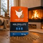 Orange-blauer Heizfuxx Holzpellets Blue 15kg Sack mit Pellets auf Holzboden vor brennendem Kamin. ENplus A1 zertifiziert.