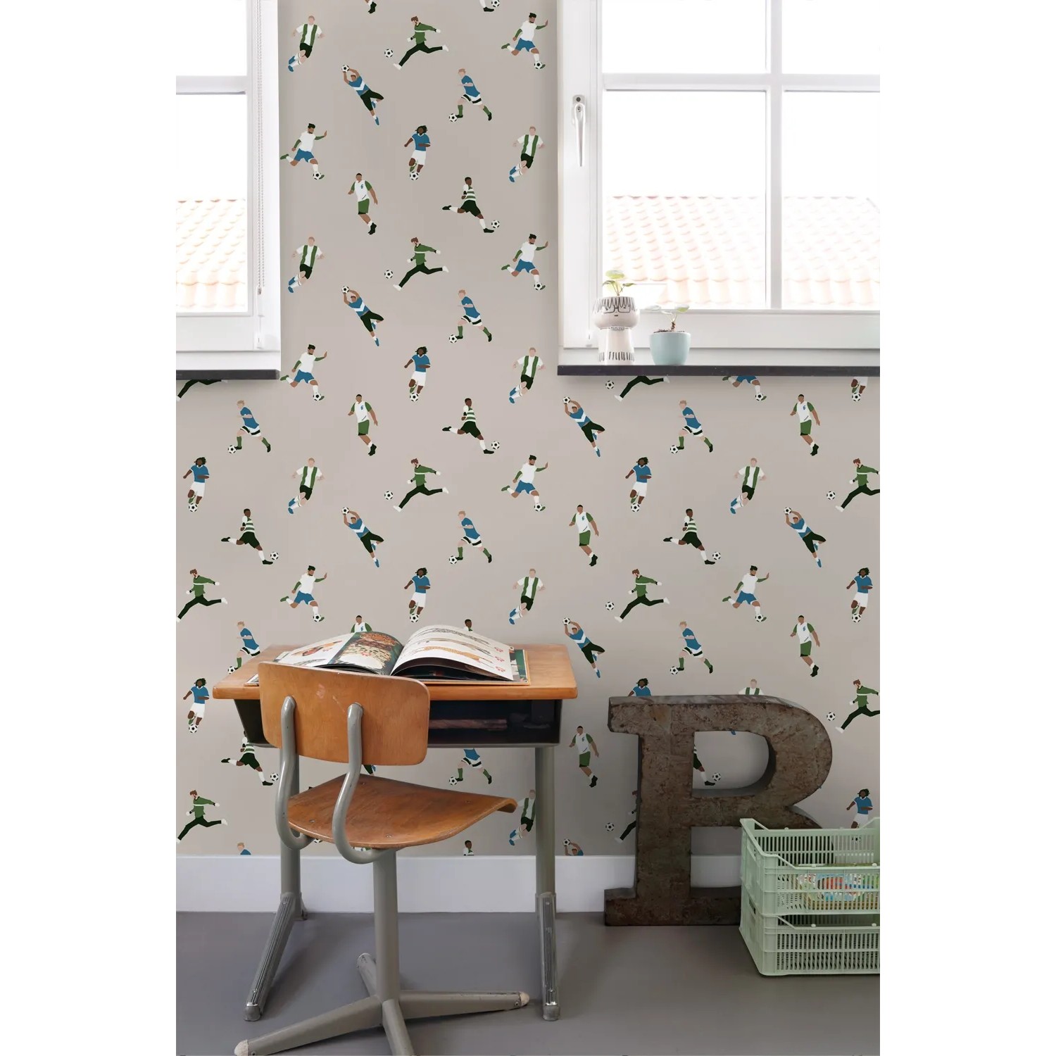 Vliestapete mit Muster aus Fußballspielern in Beige, Grün und Blau an einer Wand im Kinderzimmer.