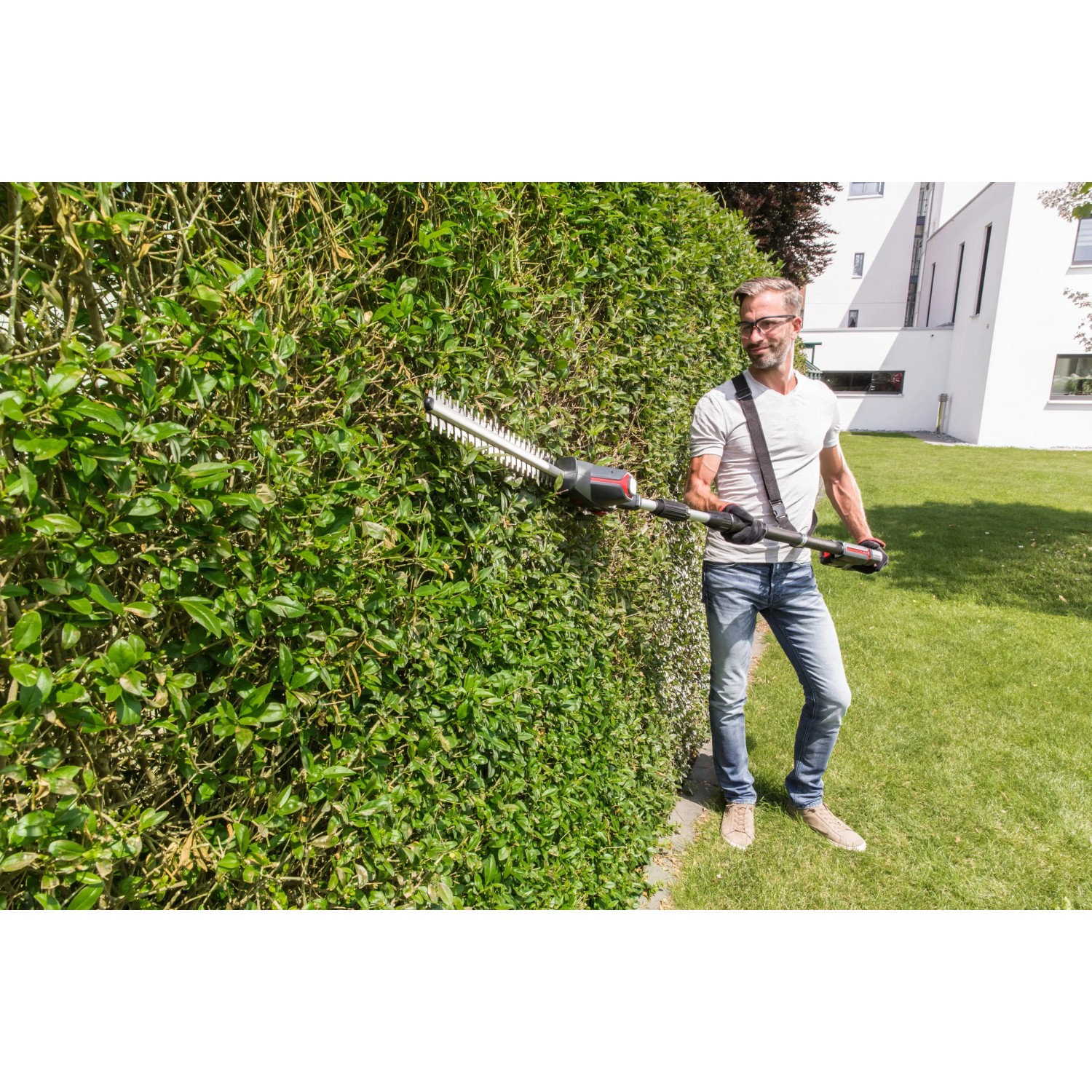Mann schneidet Hecke mit Al-Ko Akku-Hochheckenschere HTA 1845. Inkl. Akku, kompatibel mit Bosch.