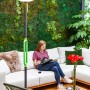 Lutec LED Solar Stehleuchte Poppy, anthrazit-grün, mit Frau auf Sofa im Hintergrund.