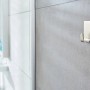 Tesa Powerstrips Haken Waterproof Zoom Edelstahl Small, 2er-Pack, an grauer Badezimmerwand.