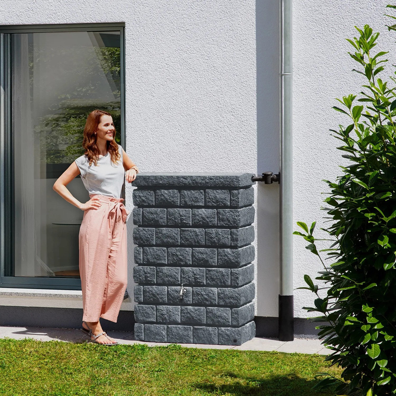 Garantia Wandtank Rocky Junior 300 l Dark Granite mit Frau im Garten.