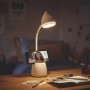 Weiße Philips LED Schreibtischleuchte Hat mit Handy im Stifthalter auf Schreibtisch.