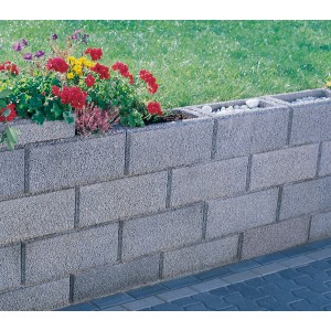 Graue Gartenmauer aus Halbsteinen (25x25x20 cm) mit Bepflanzung, ideal zur Grundstückseinfassung.
