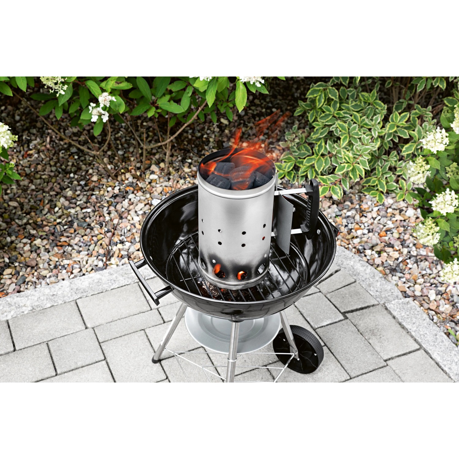 Landmann Anzündkamin aus Edelstahl mit Holzkohle auf einem Grill.