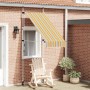 Gelb-blau gestreifte, handbetriebene Einziehmarkise an Ziegelwand über Fenster. Ideal als Schattenspender für Terrasse.