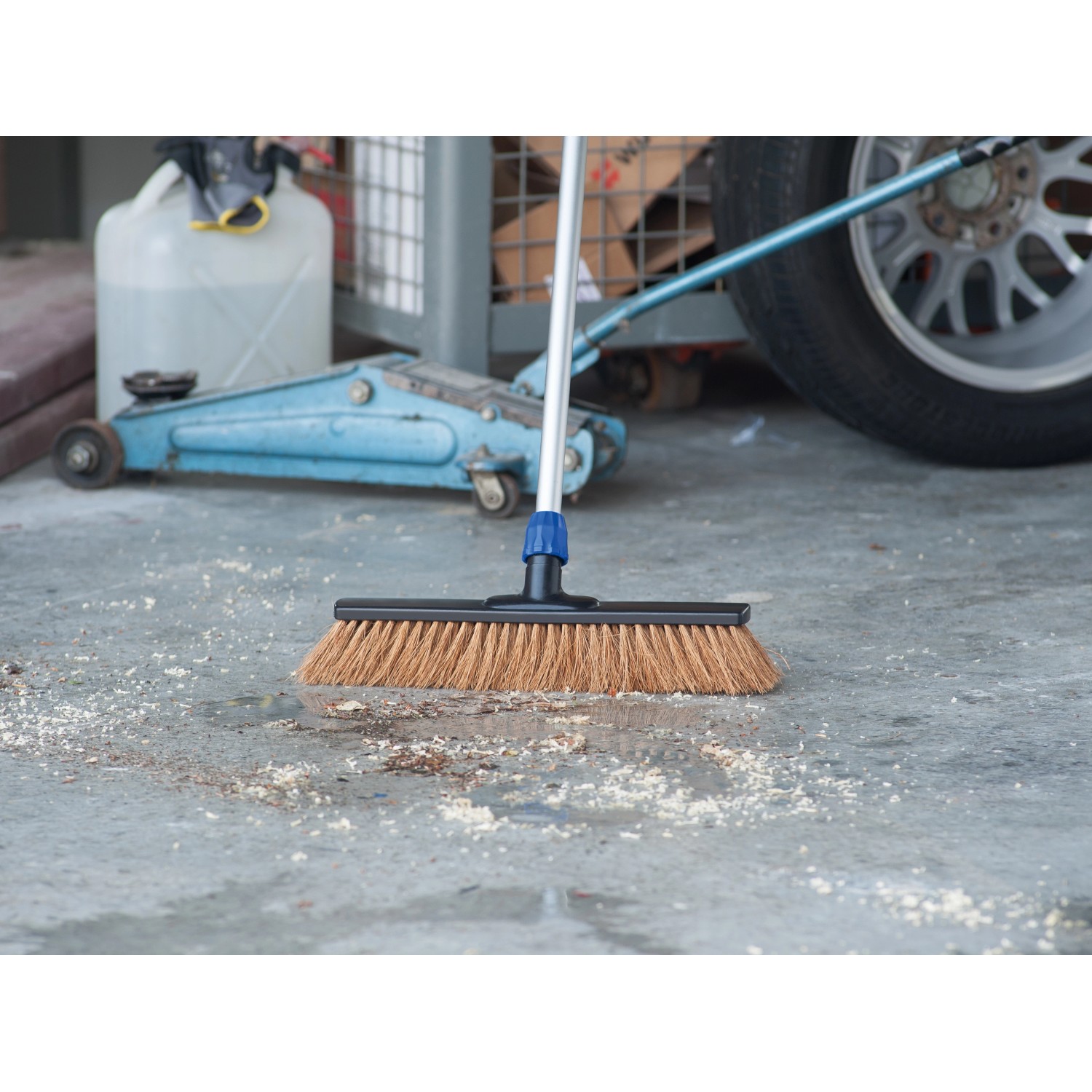 LUX Besenkopf Professional Kokos 40 cm beim Kehren von Schmutz auf Betonboden.