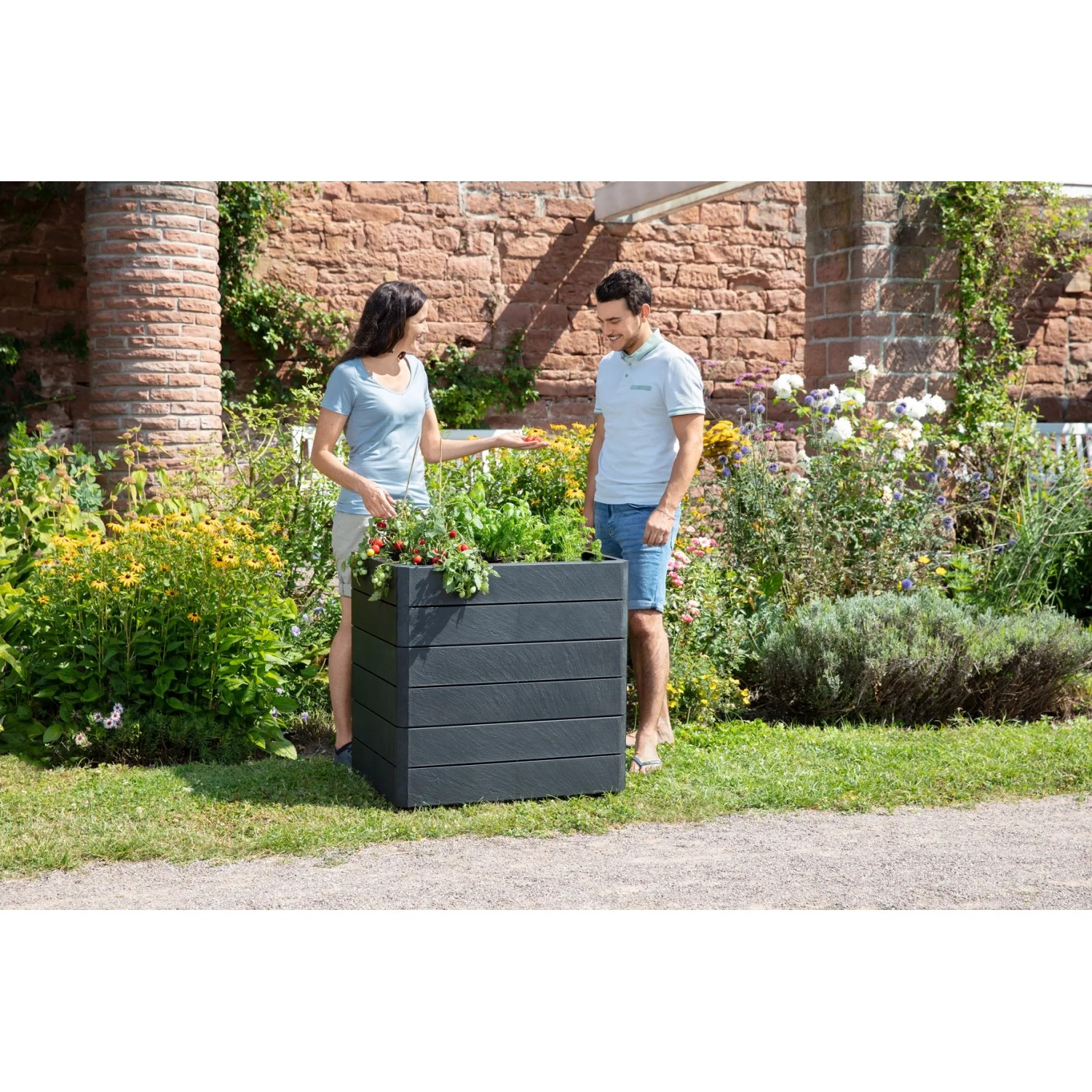 Garantia Hochbeet Ergo Quadro M 75 Stone mit Personen im Garten, Kunststoff-Hochbeet in Steinoptik.