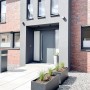 Anthrazitfarbener Vivanno Pflanzkübel Maxi (120x45x45 cm) vor modernem Haus.