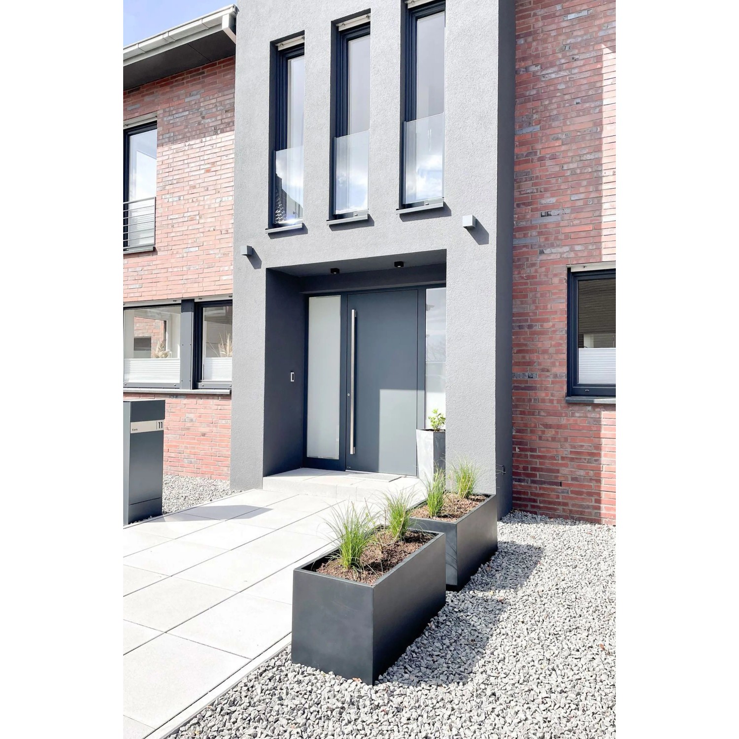 Anthrazitfarbener Vivanno Pflanzkübel Maxi (120x45x45 cm) vor modernem Haus.